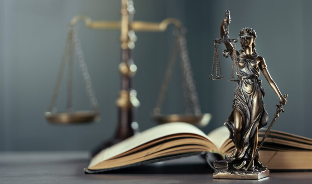 Law book, Statue of Lady Justice holding scales and sword and huge Scales